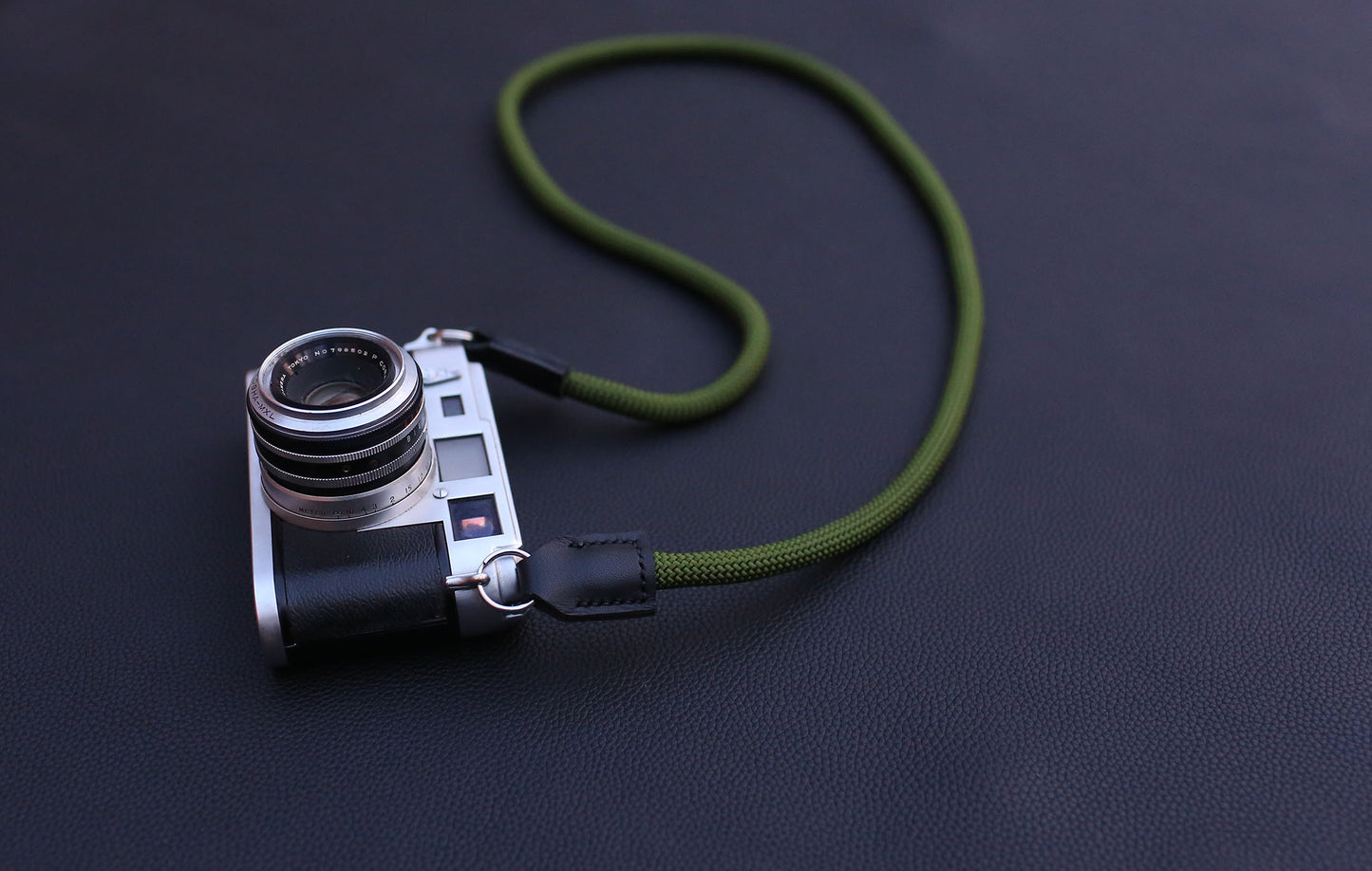 army green 10 mm rope strap coiled beside camera