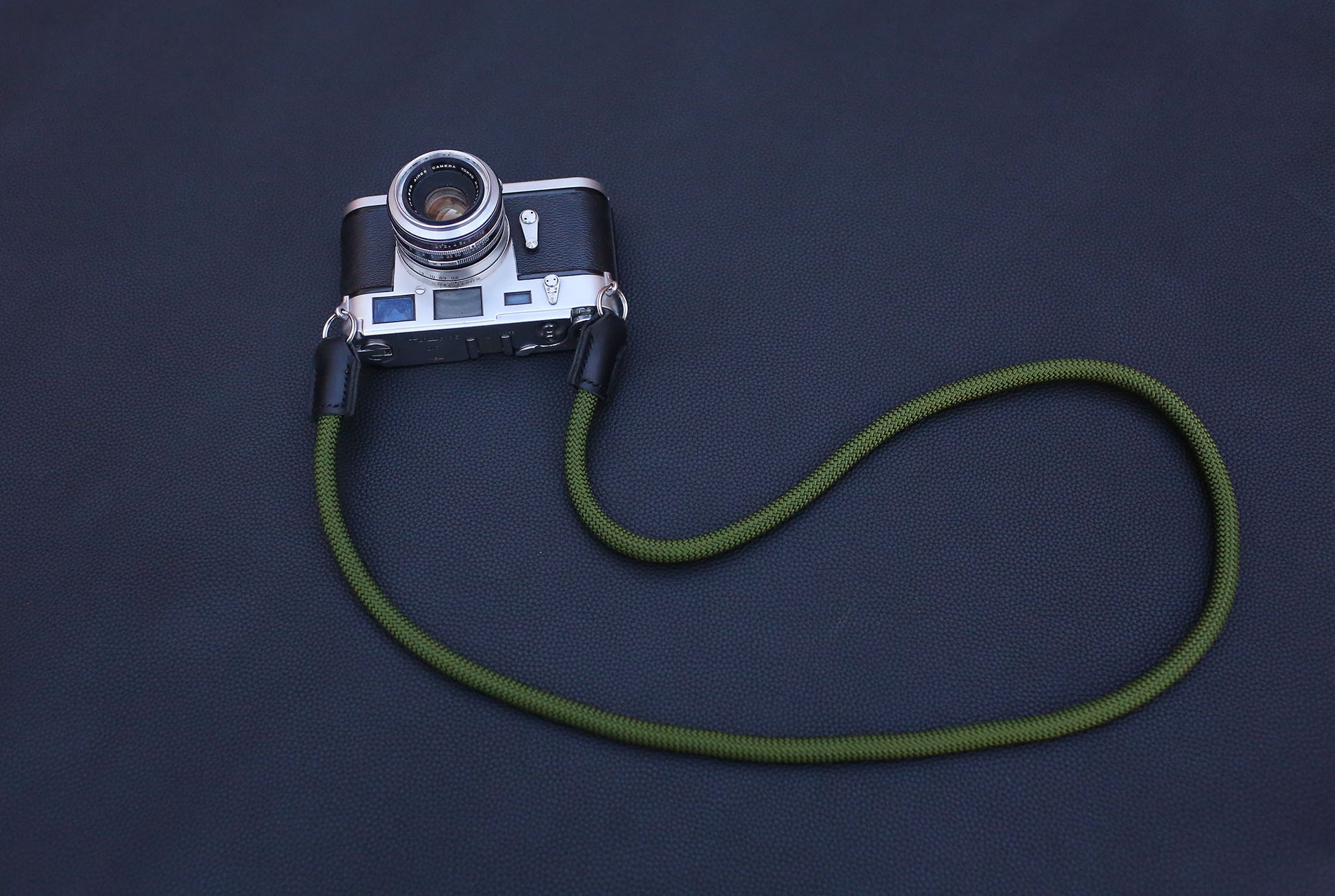 minimal profile rope camera strap on black background