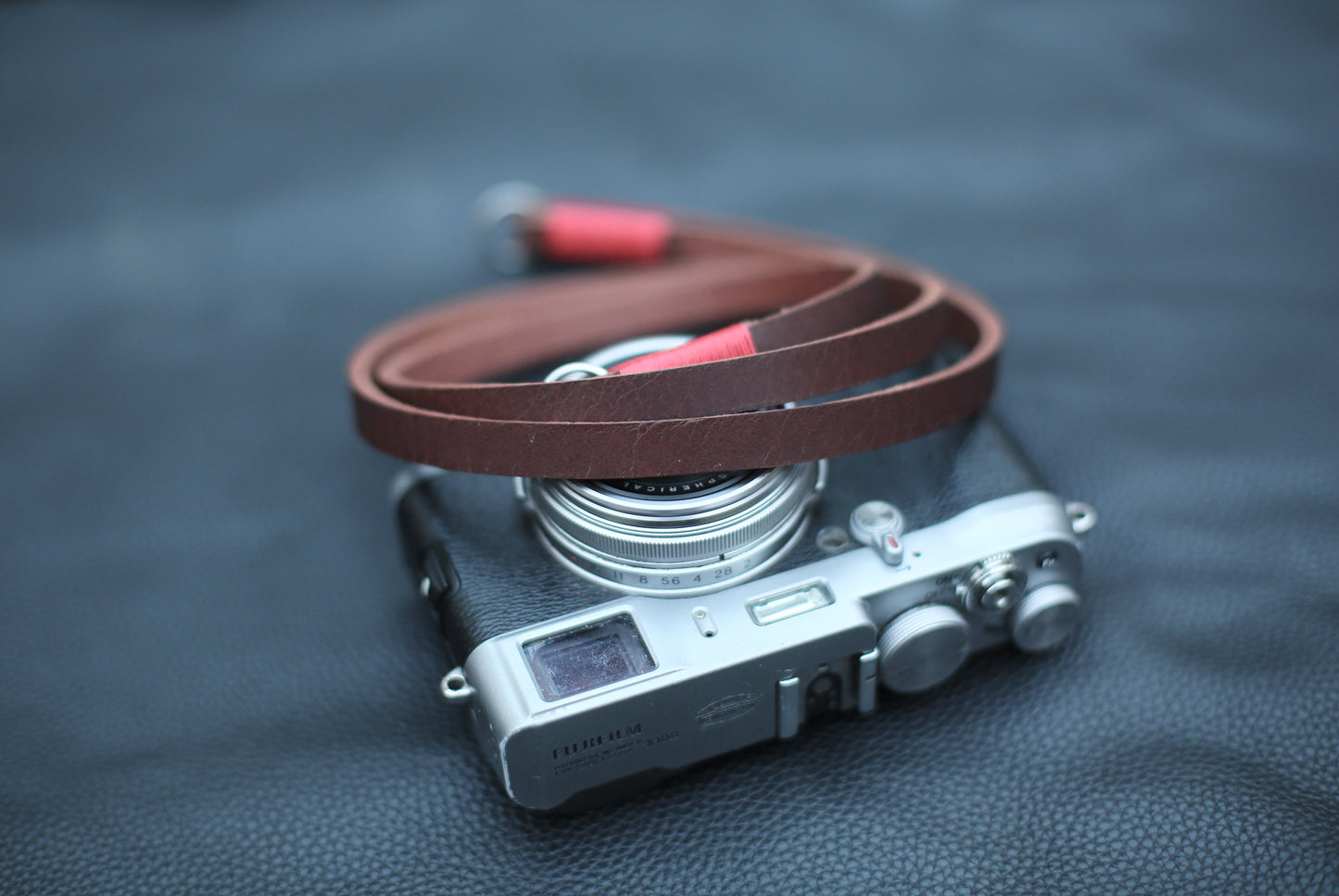 Handcrafted leather camera strap on dark background