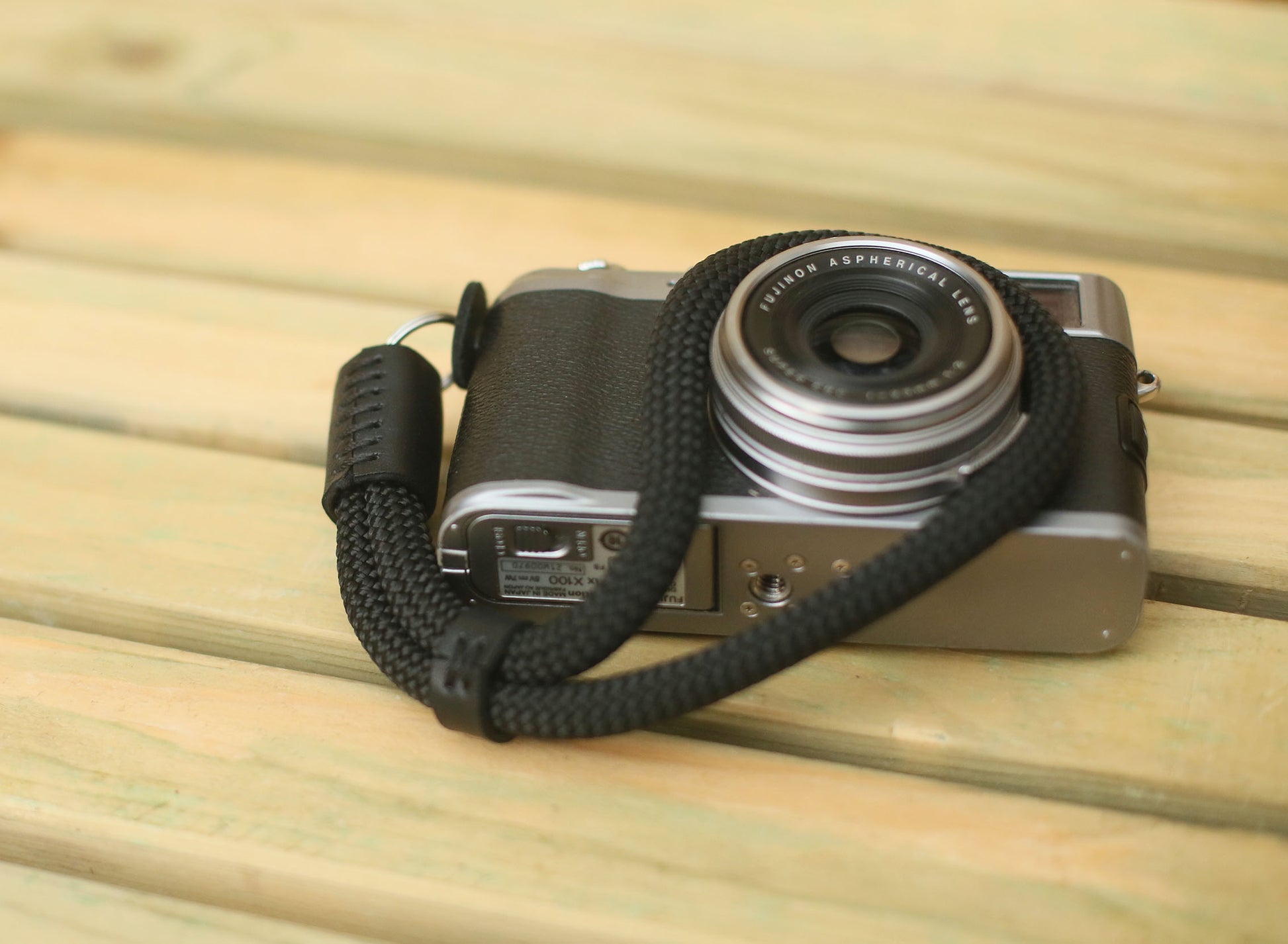 Photographer holding camera with all-black wrist strap