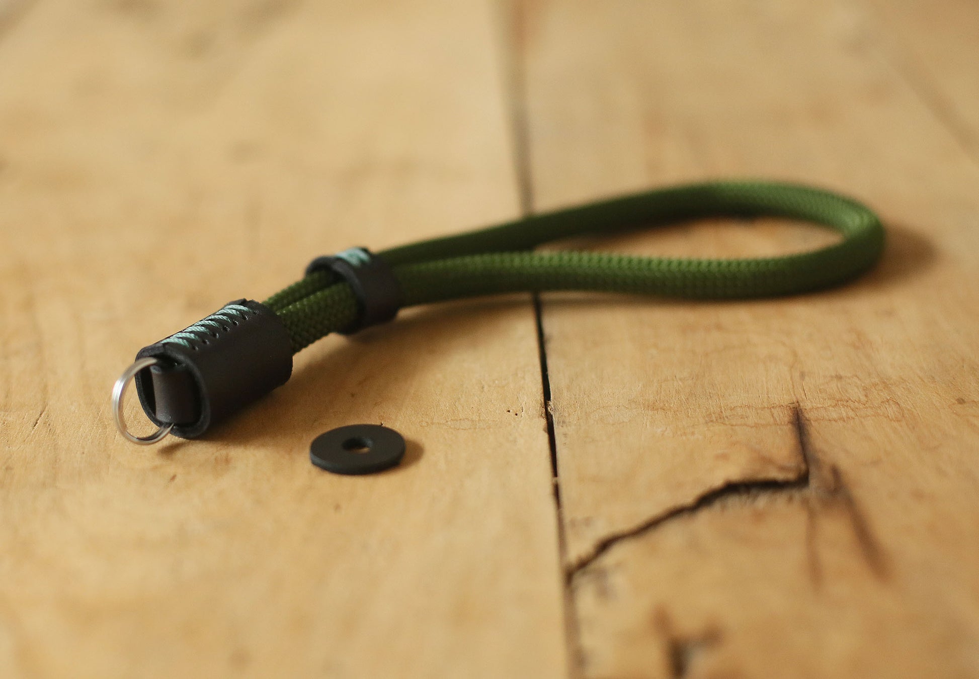 Military green rope camera strap attached to vintage camera
