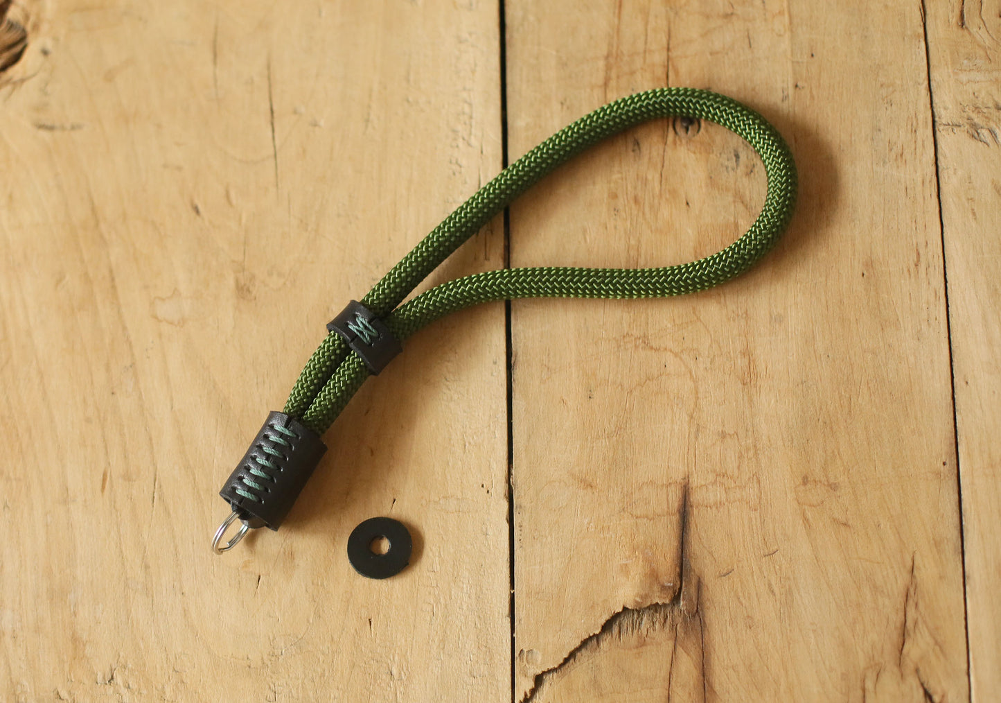 Photographer holding camera with green climbing rope wrist strap