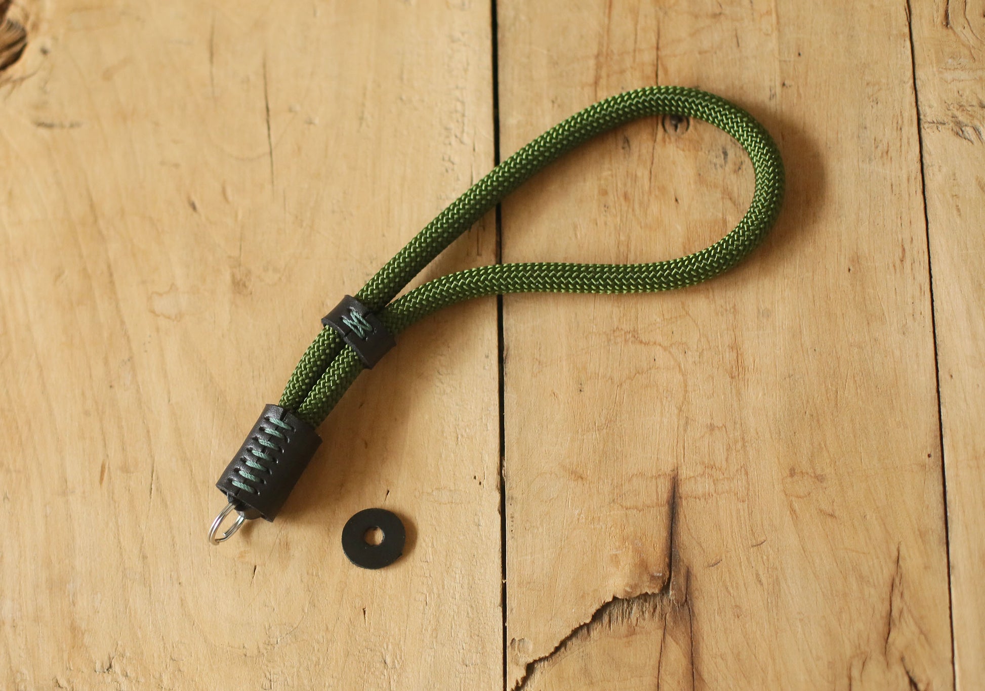 Photographer holding camera with green climbing rope wrist strap