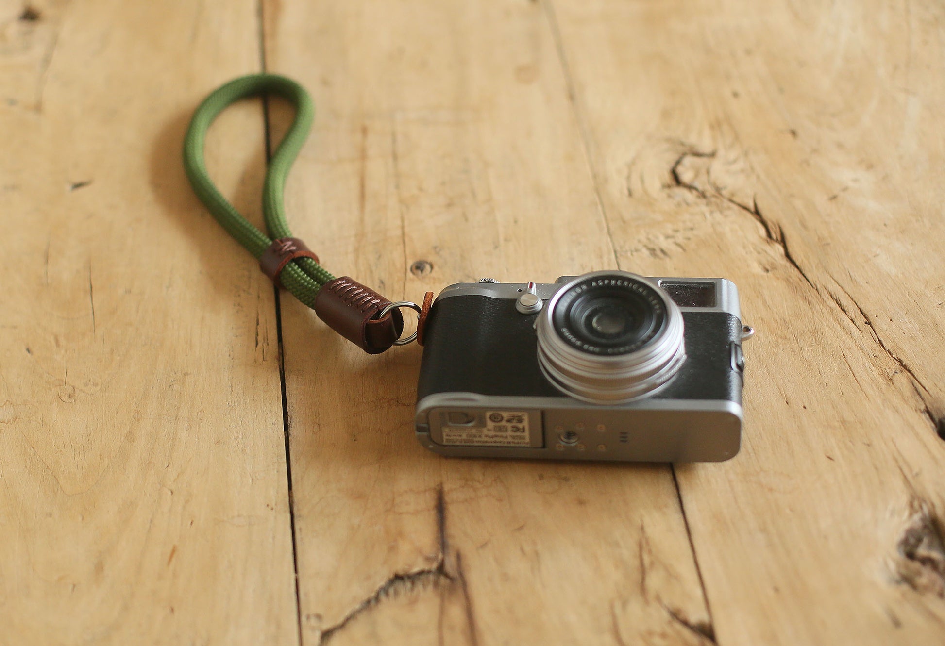 Close-up of tan leather accent on green rope strap