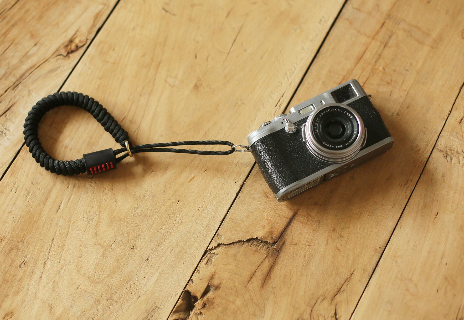 Black leather cylindrical end with red wax stitching on wrist strap