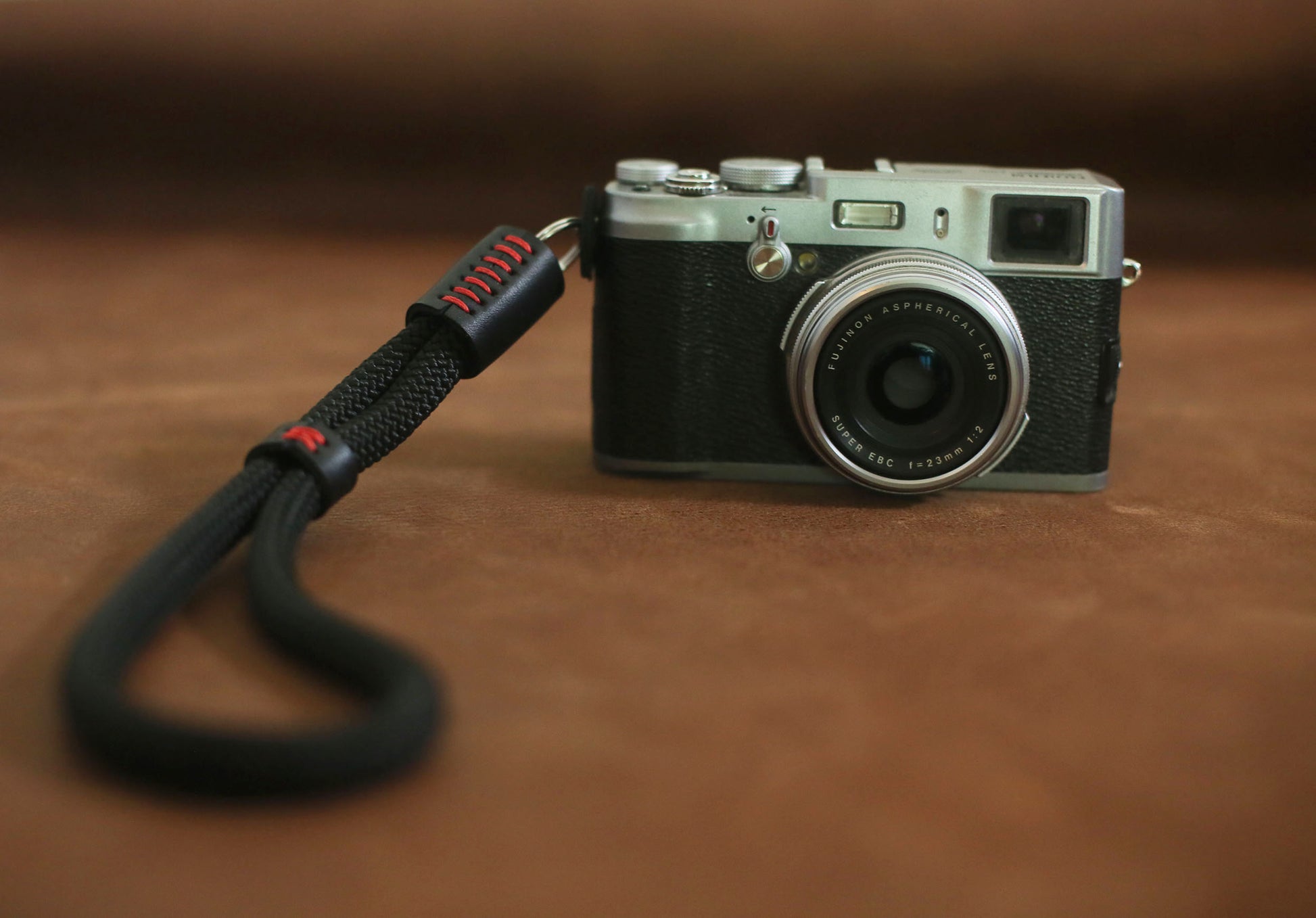 Photographer holding camera with black rope wrist strap