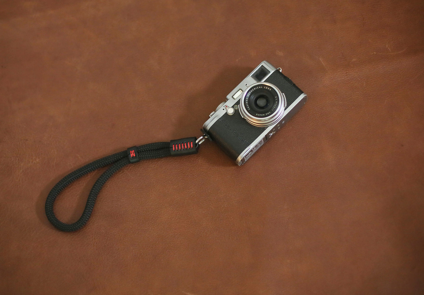 Black and red camera wrist strap flat lay