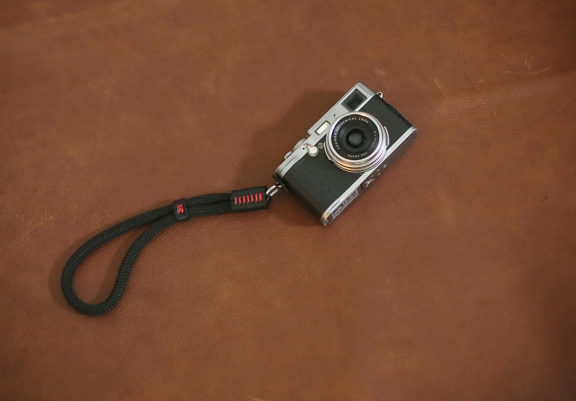 Black and red camera wrist strap flat lay