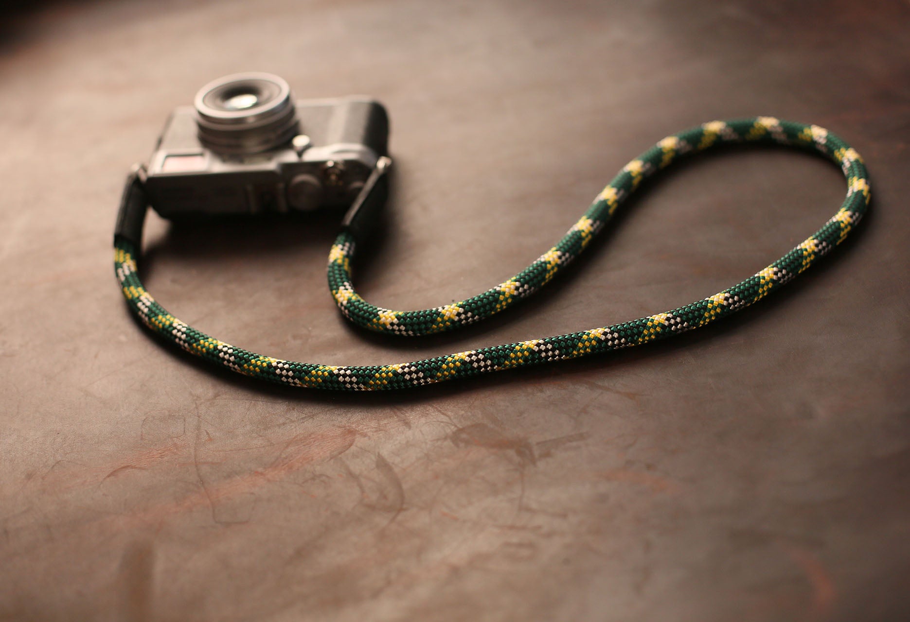 Close-up of leather and rope connection on handmade camera strap