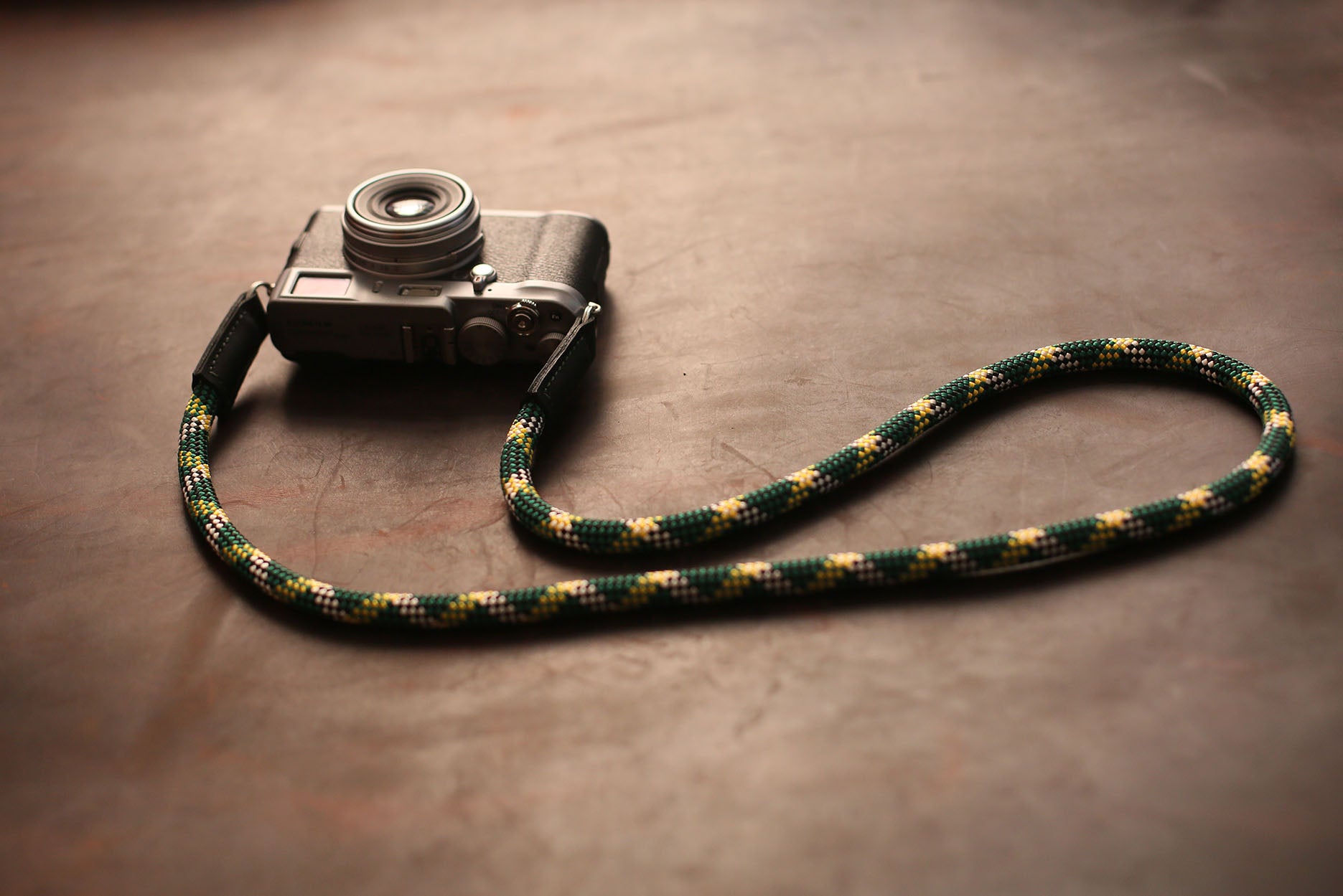 Green and yellow woven rope strap attached to retro camera