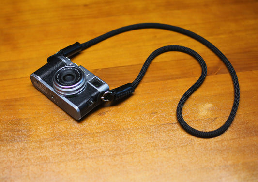 Overhead view of black rope strap forming gentle curve on surface