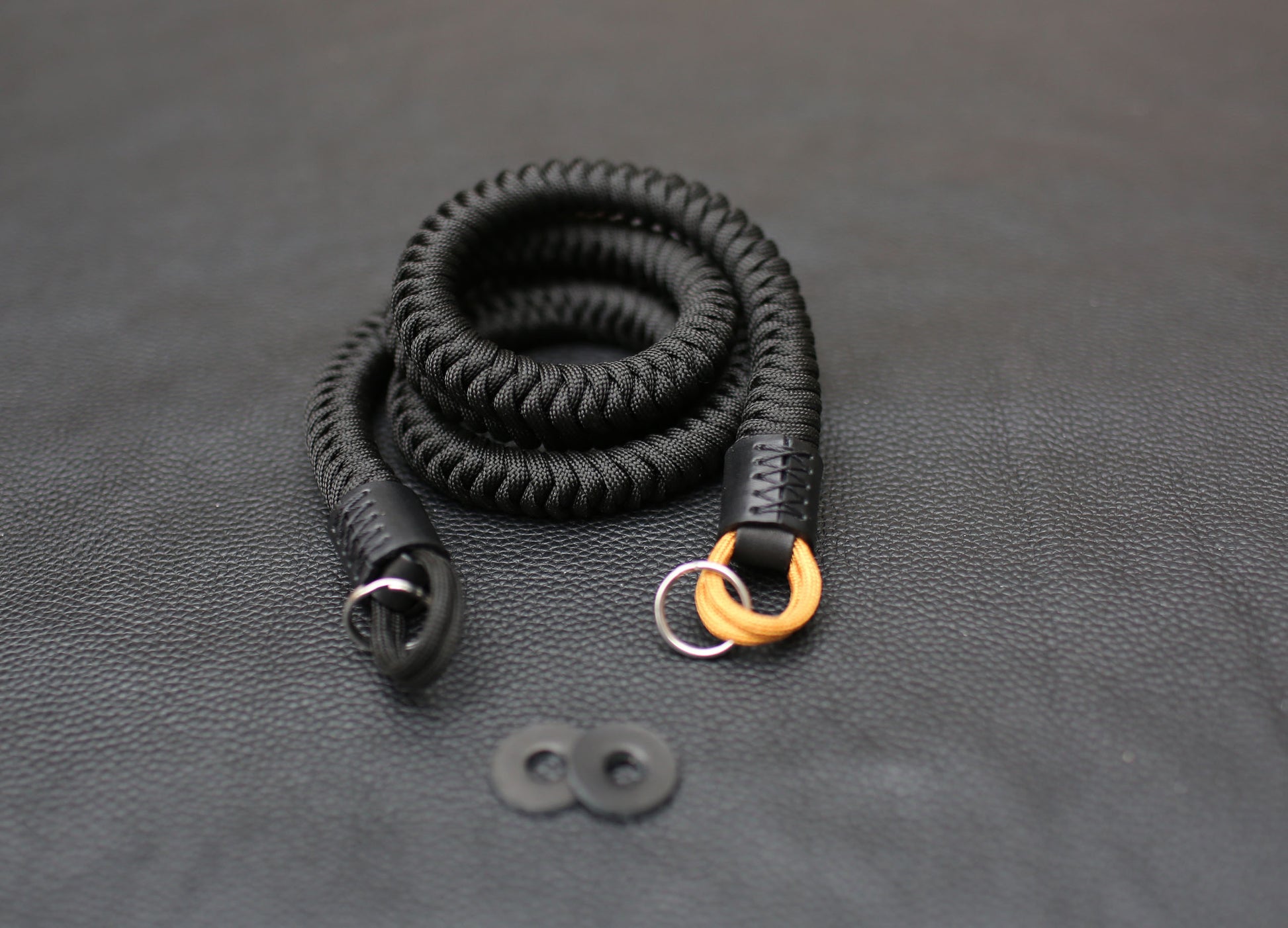 Black leather strap end with gold paracord detail