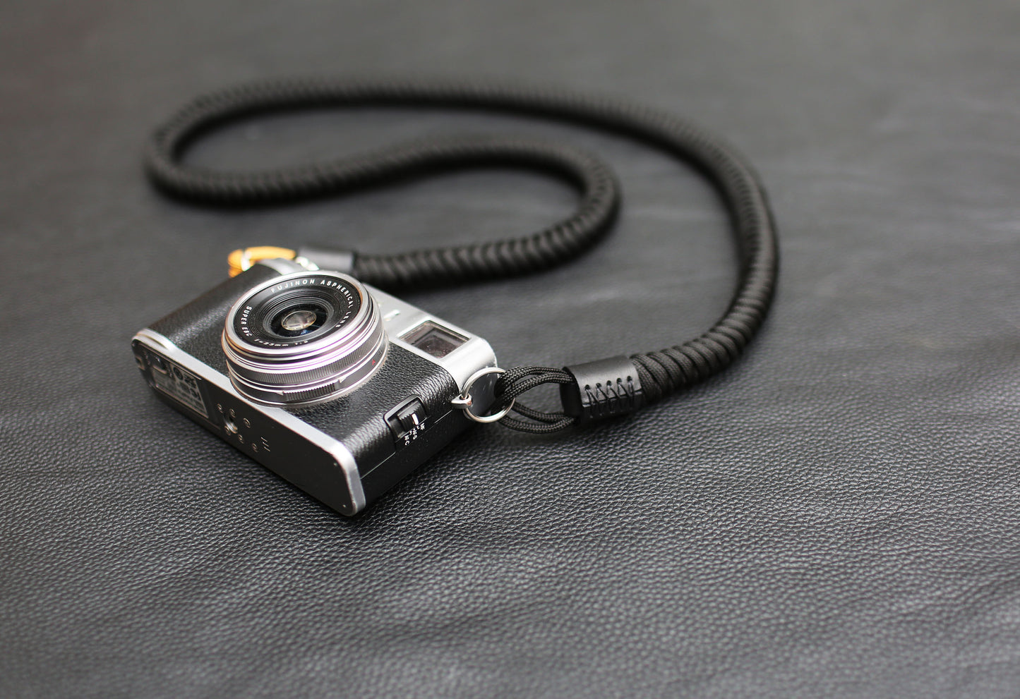 Photographer wearing black and gold paracord camera strap