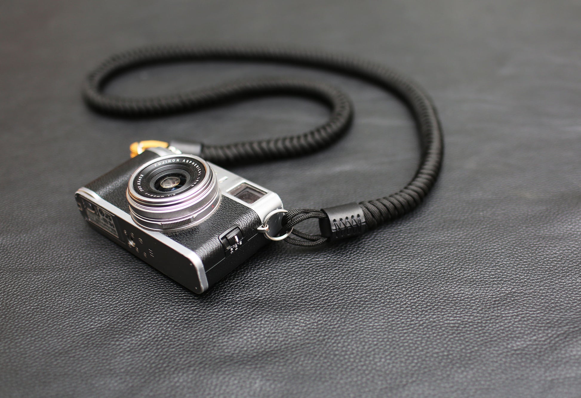 Photographer wearing black and gold paracord camera strap