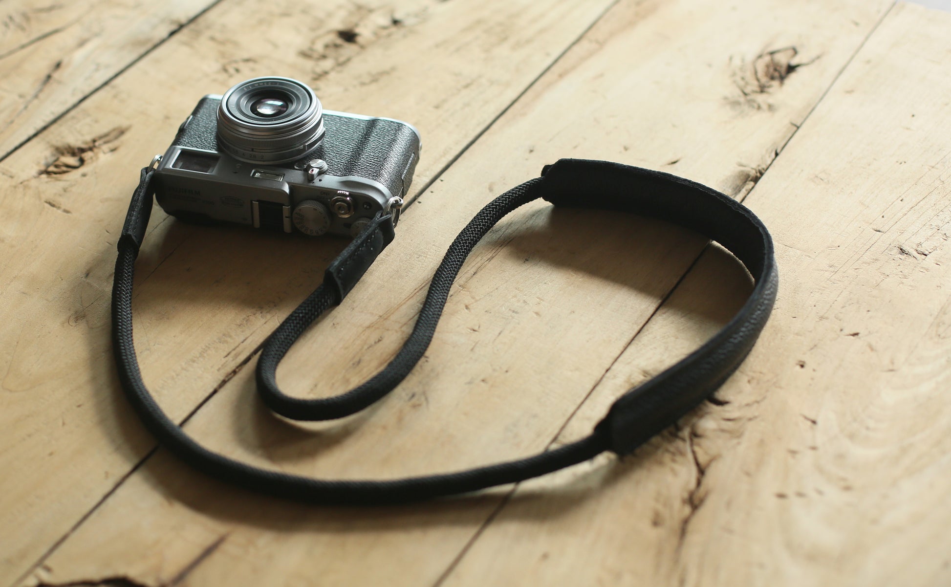 Full length view of black 10mm rope camera strap with leather pad