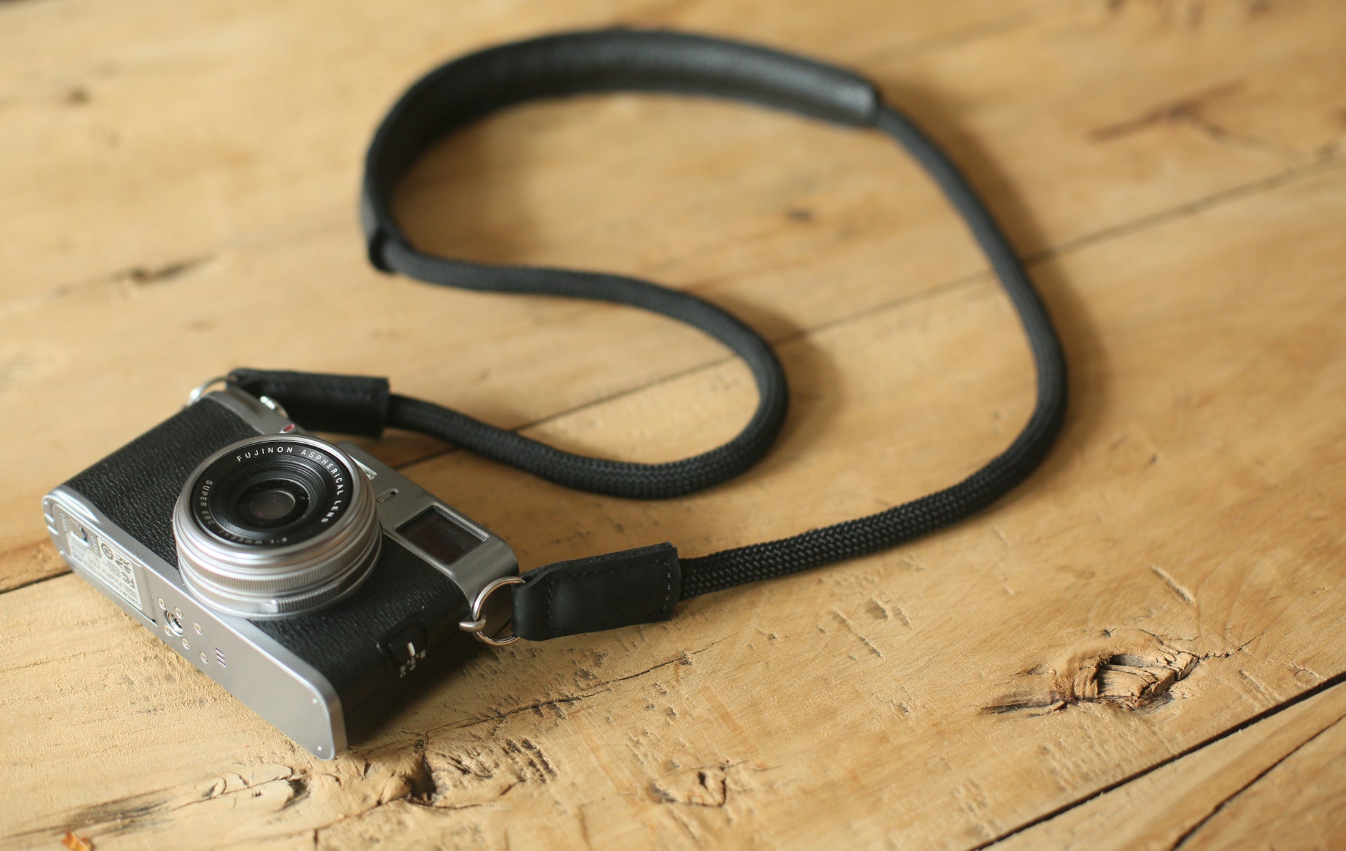 Camera strap worn around neck showing position of leather shoulder pad