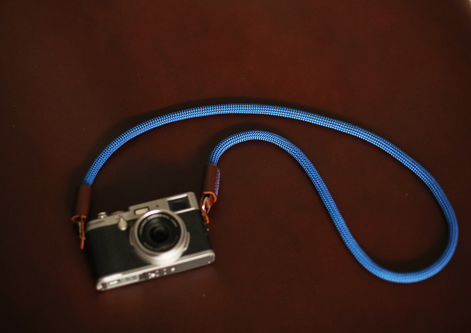 blue and tan two-tone camera strap on table