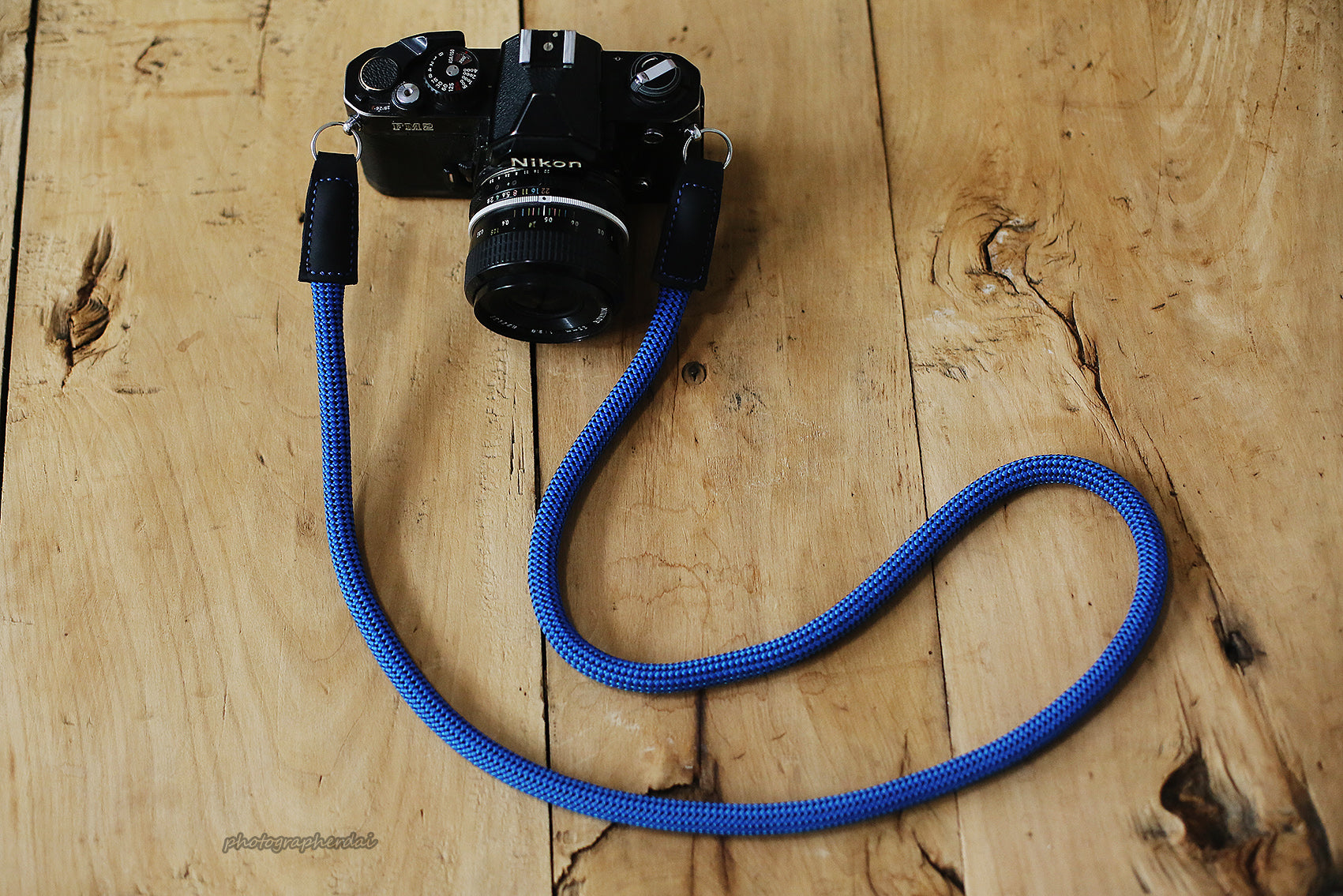 Blue rope camera strap with black dotted pattern attached to camera body