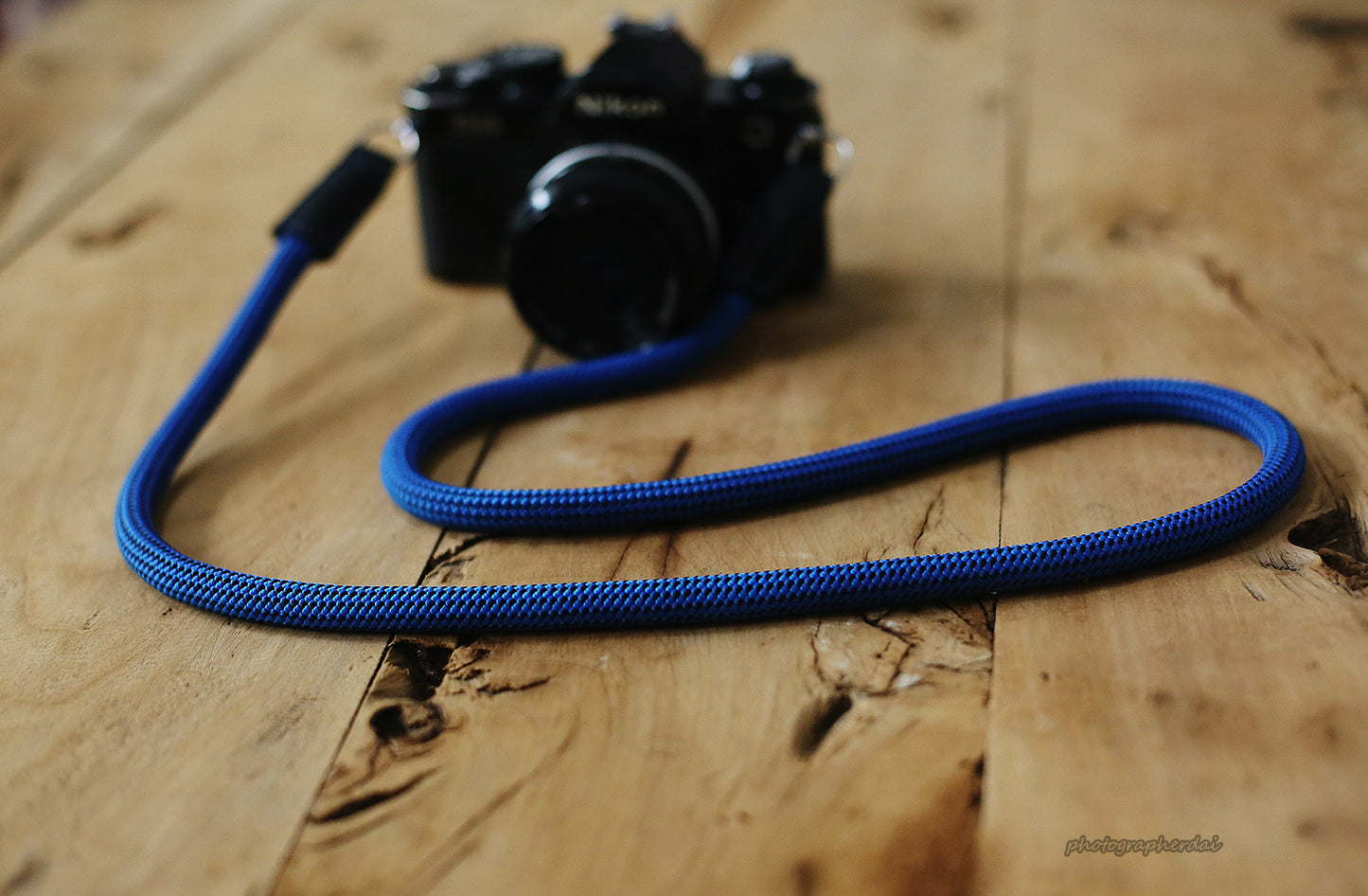 Full length display of blue rope camera strap with dotted pattern and leather ends