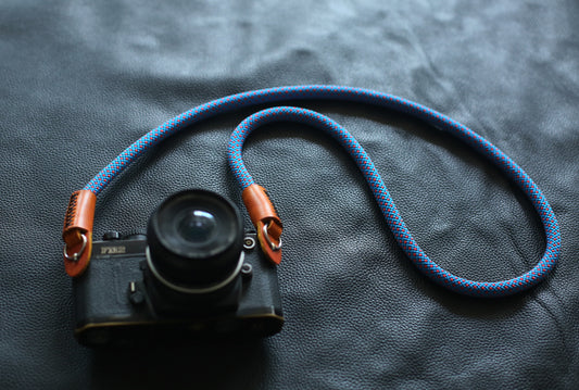 blue red rope camera strap on black leather background