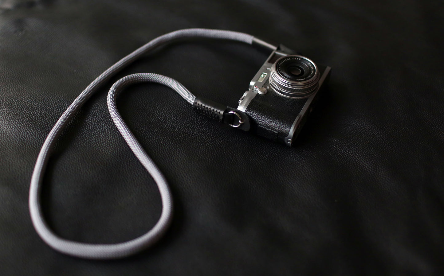 Fujifilm camera with attached gray climbing rope strap