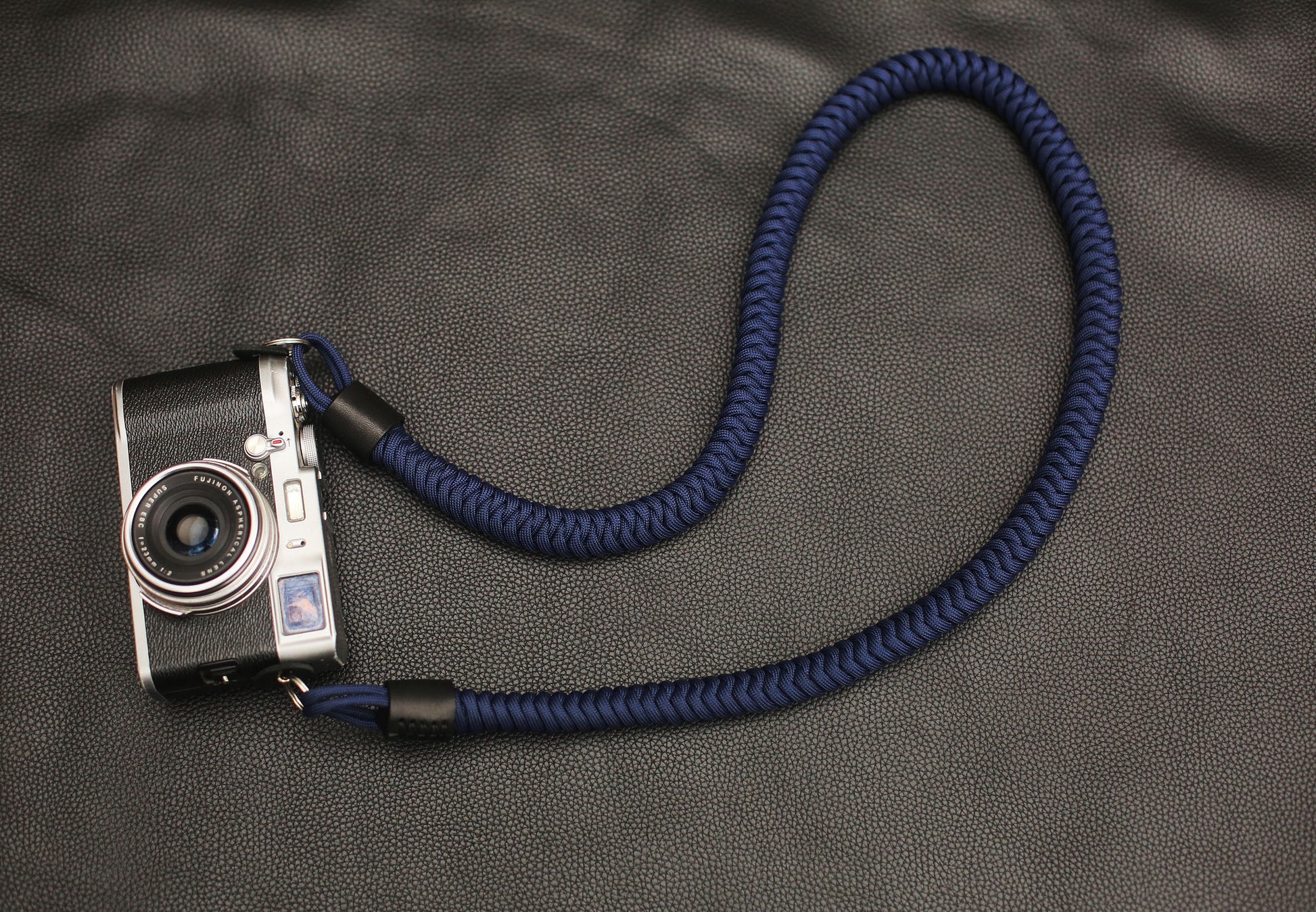 Overhead shot of navy blue camera strap in gentle curve
