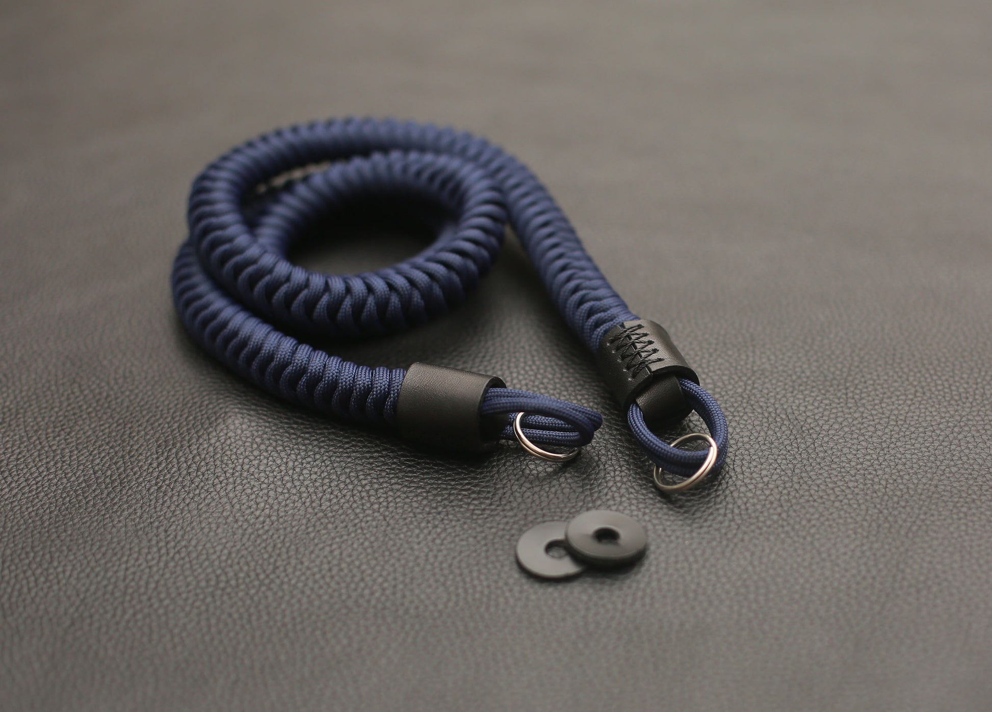 Leather protector pad with metal split ring attached to strap