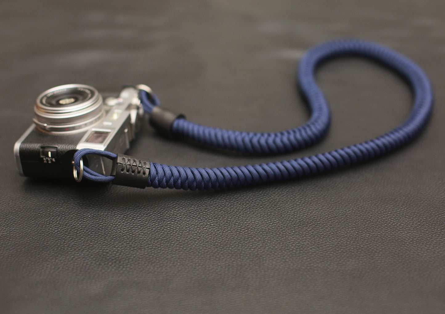 Navy paracord strap displayed with vintage rangefinder camera