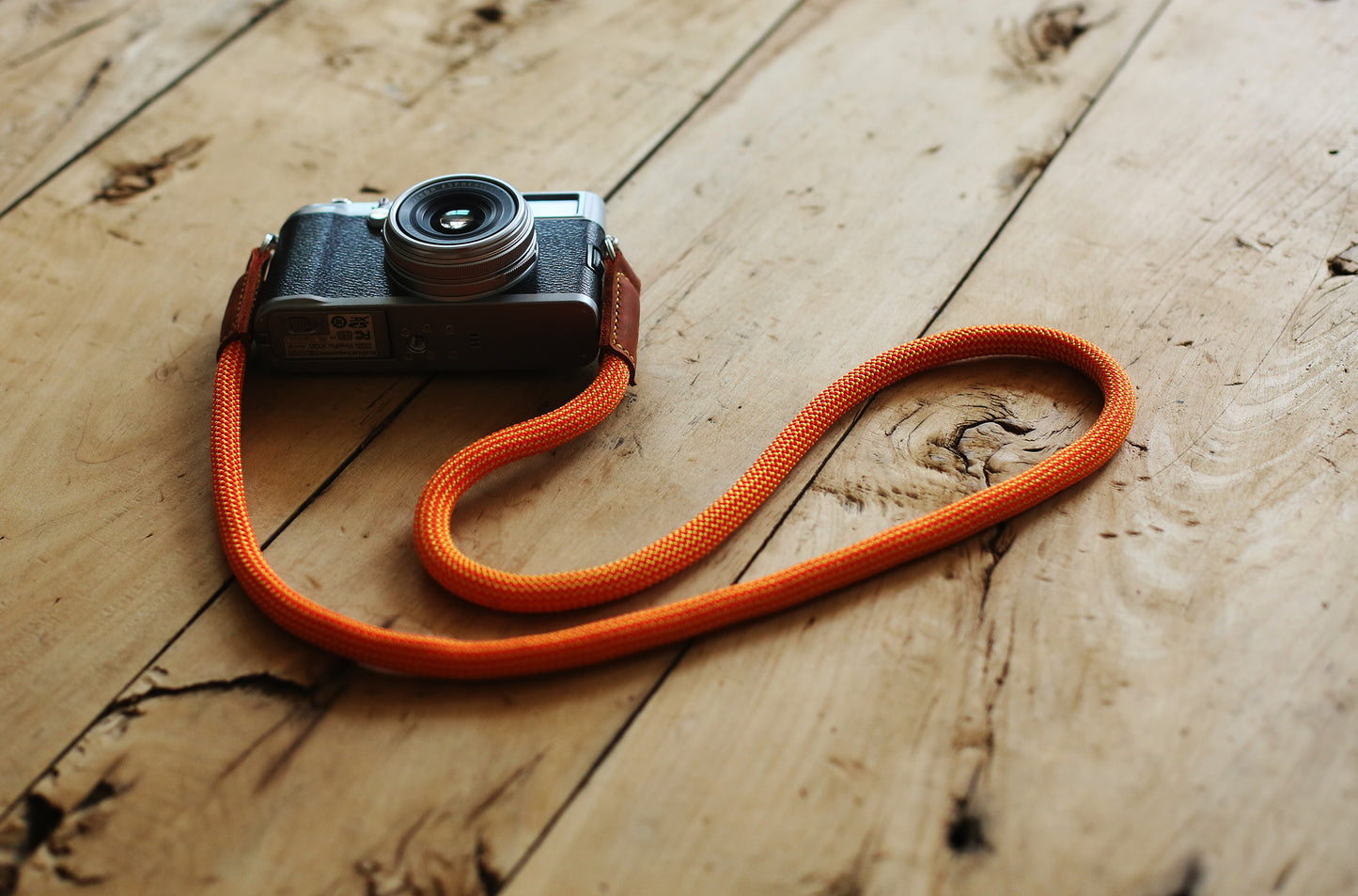 orange rope camera strap on wooden background