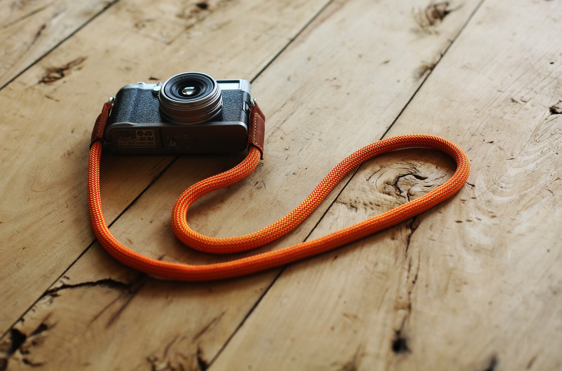 orange rope camera strap on wooden background