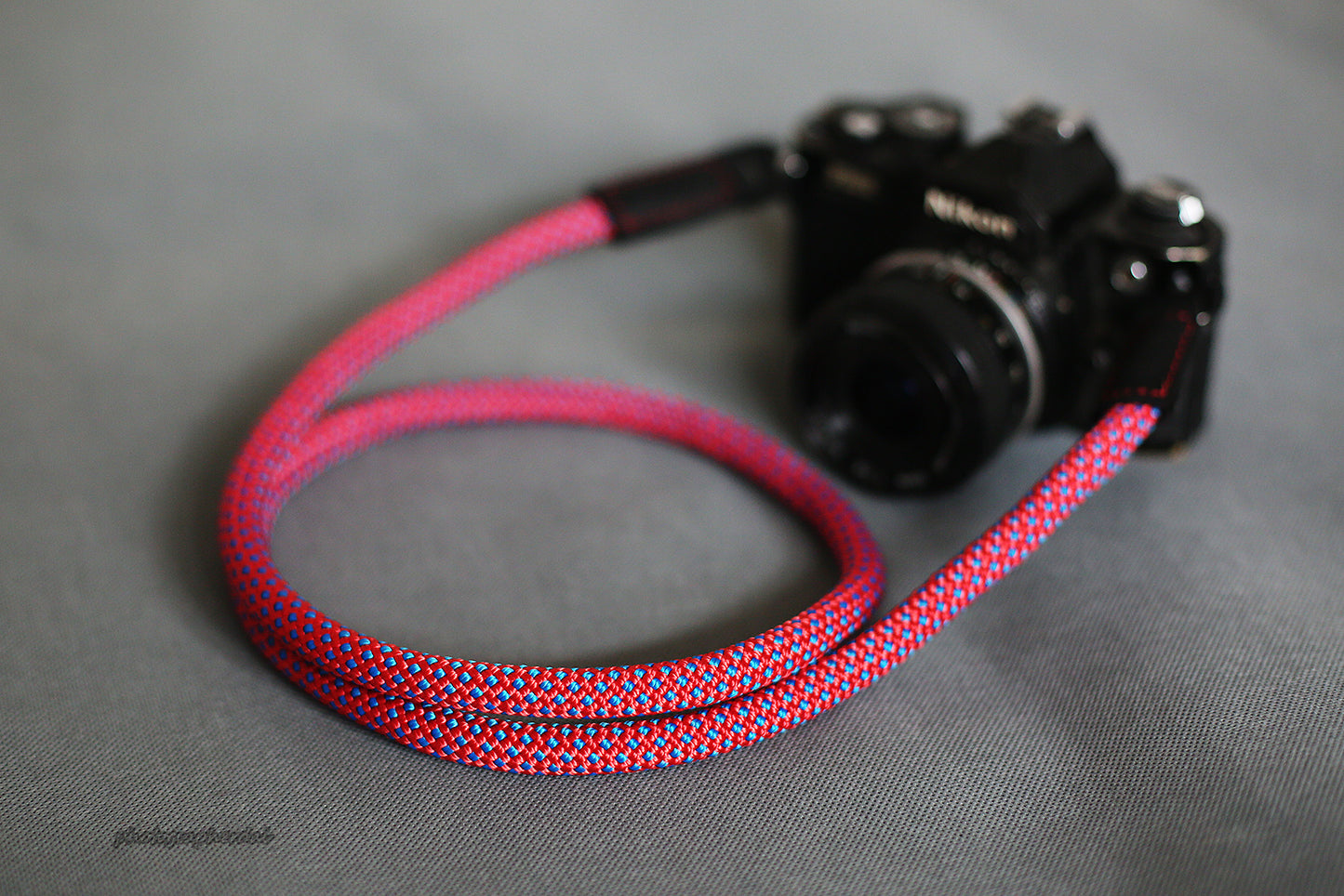 Purple climbing rope camera strap front view on white background