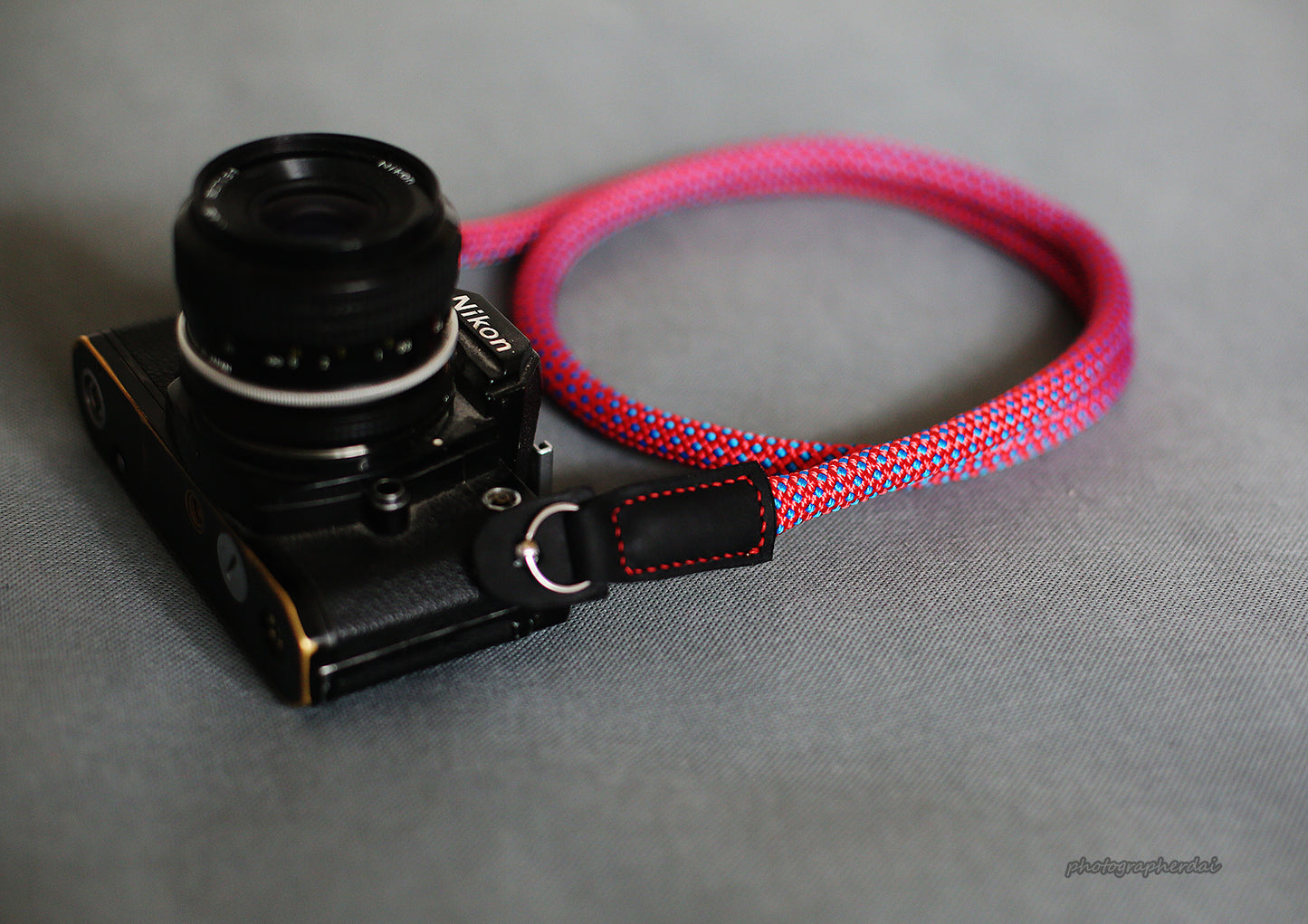 Close up of full grain leather ends and metal rings on purple camera strap