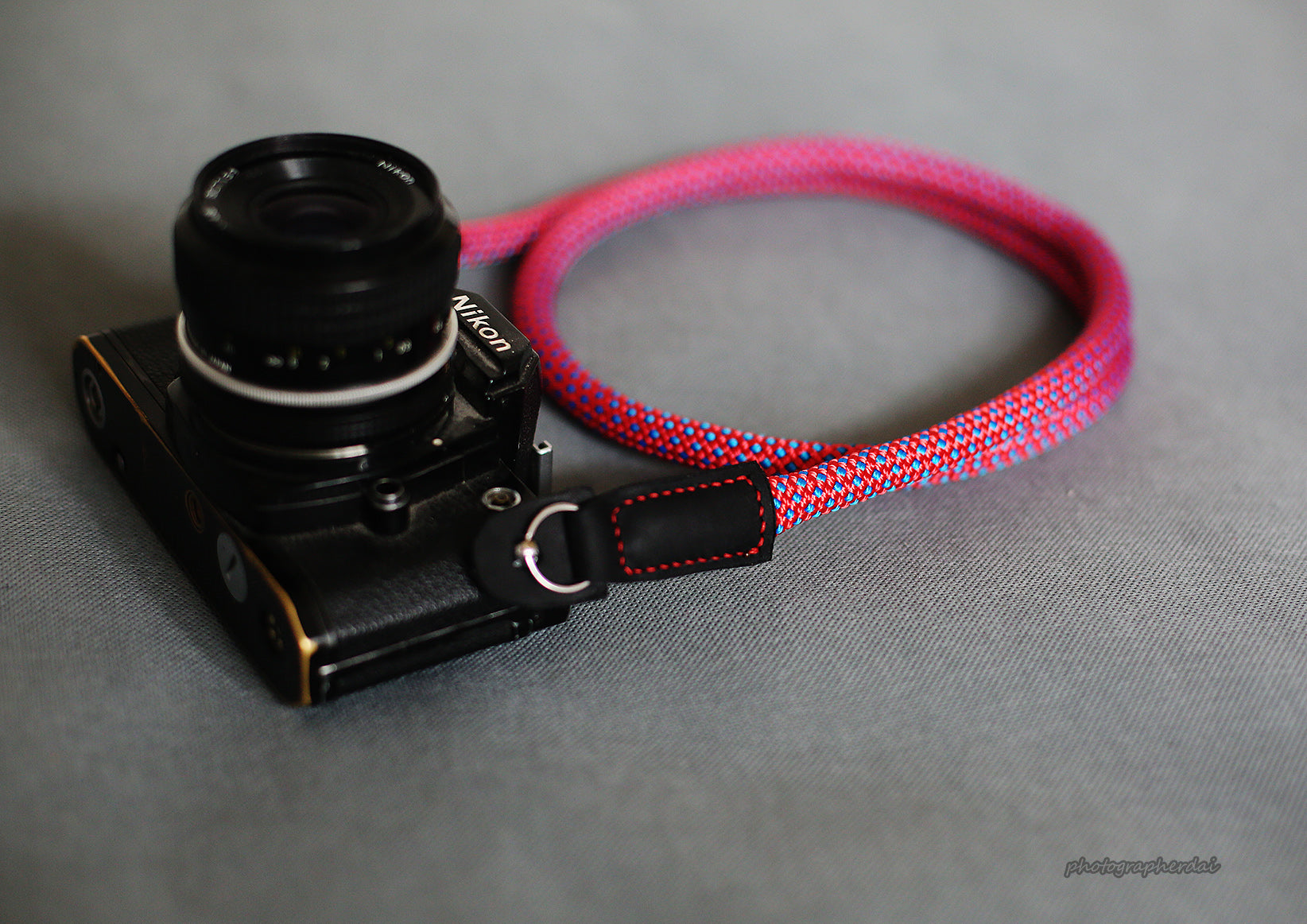 Close up of full grain leather ends and metal rings on purple camera strap