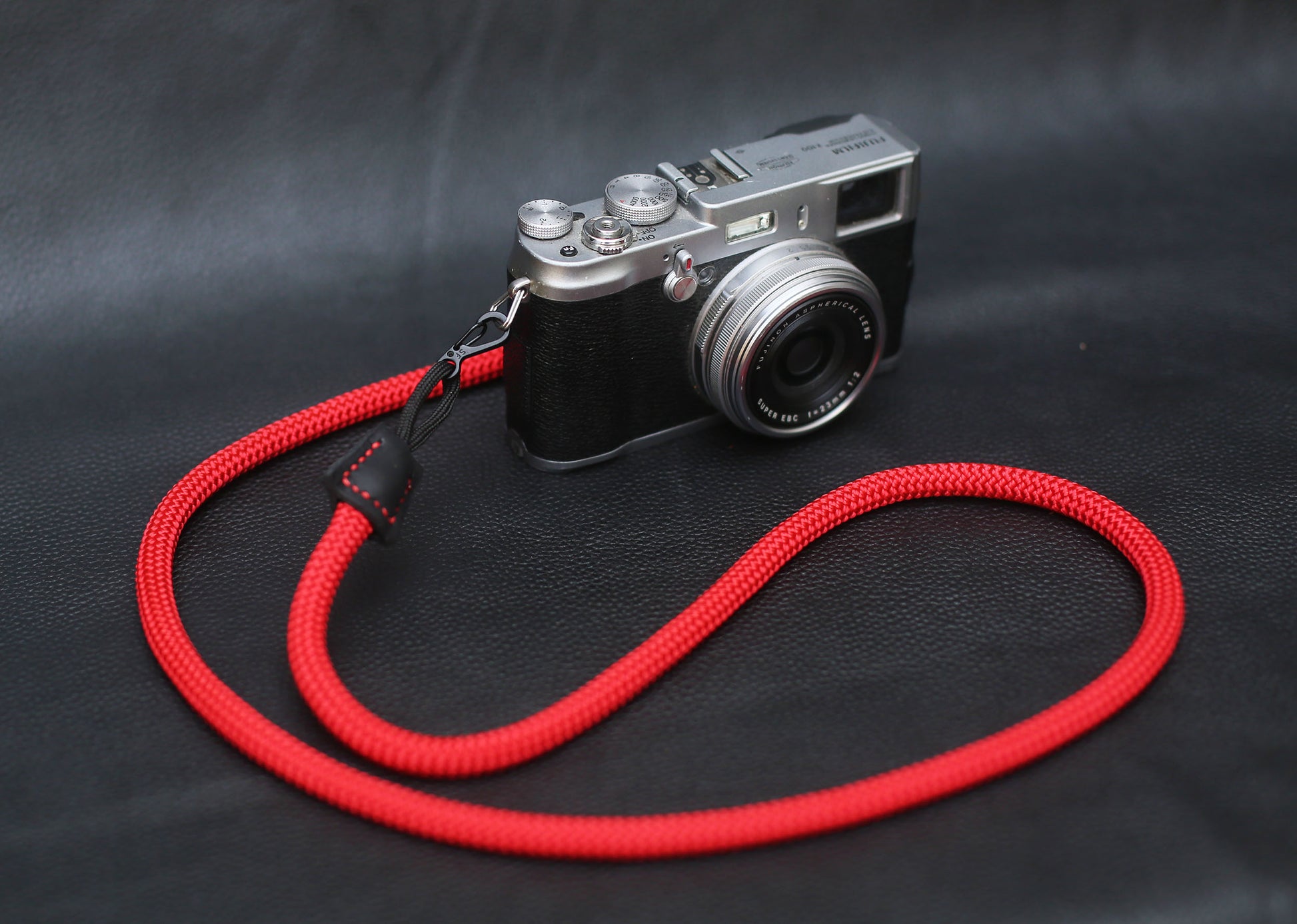 Top-down photo of red strap with compact camera setup