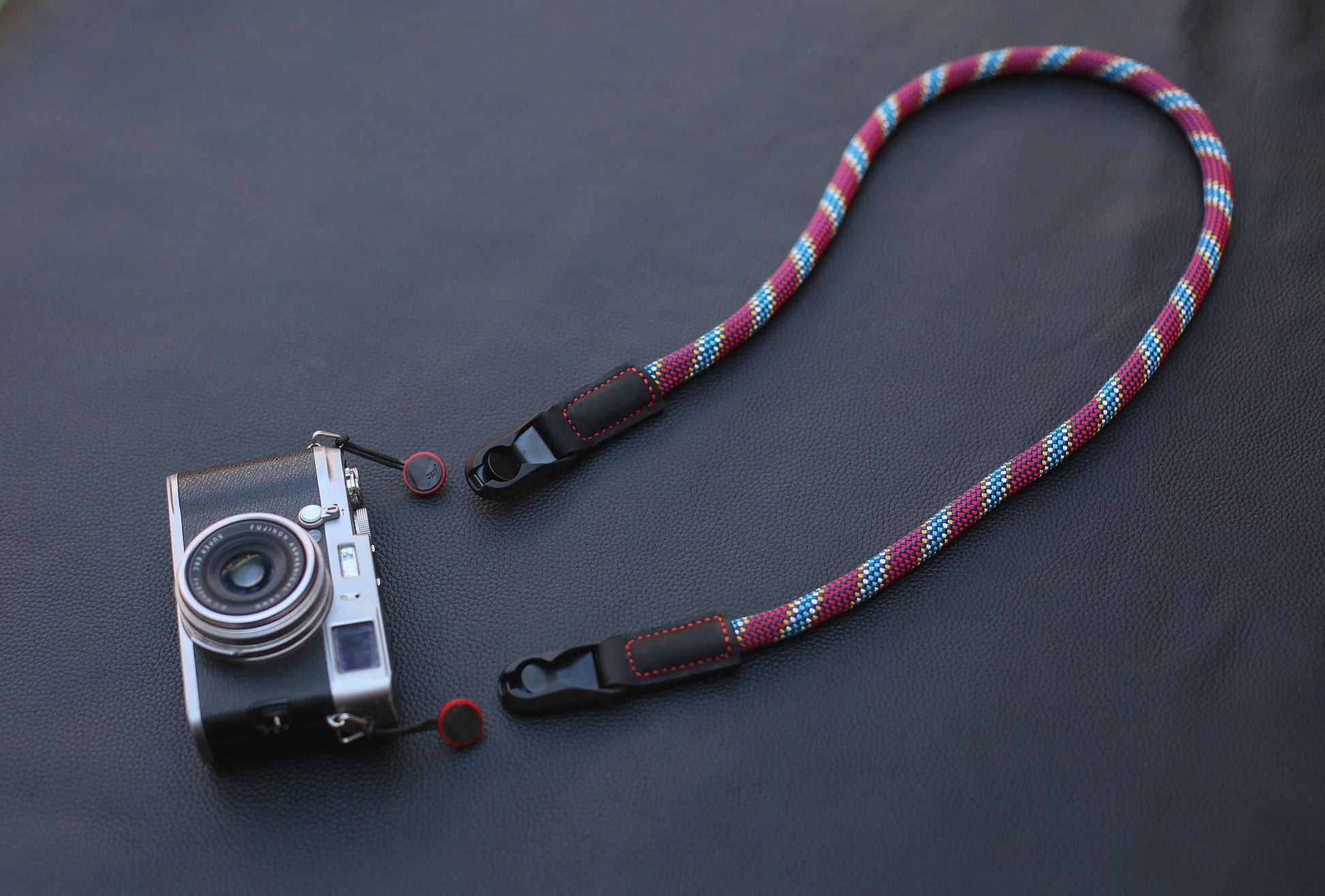 Full view of red pattern rope strap on dark leather background