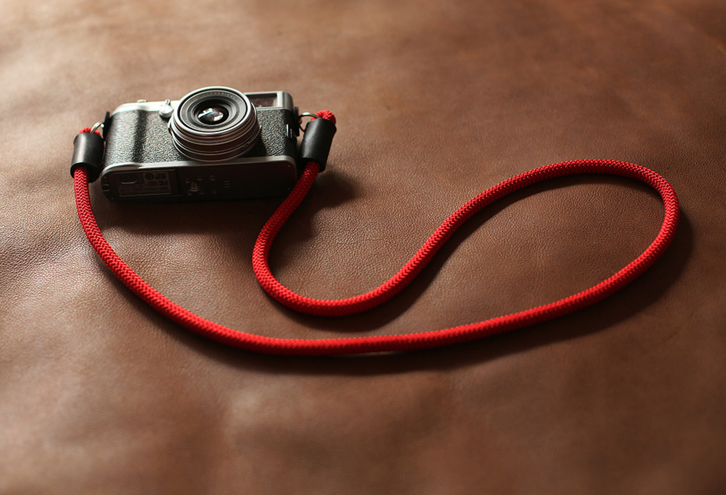 Coiled red 8mm camera strap with leather protectors