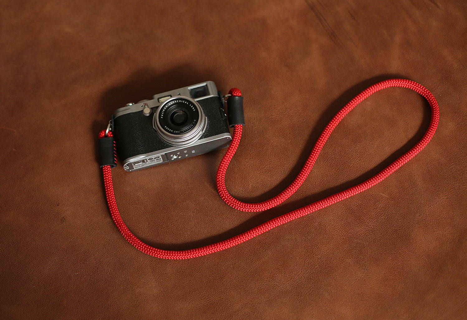 Side angle view of lightweight red rope camera strap