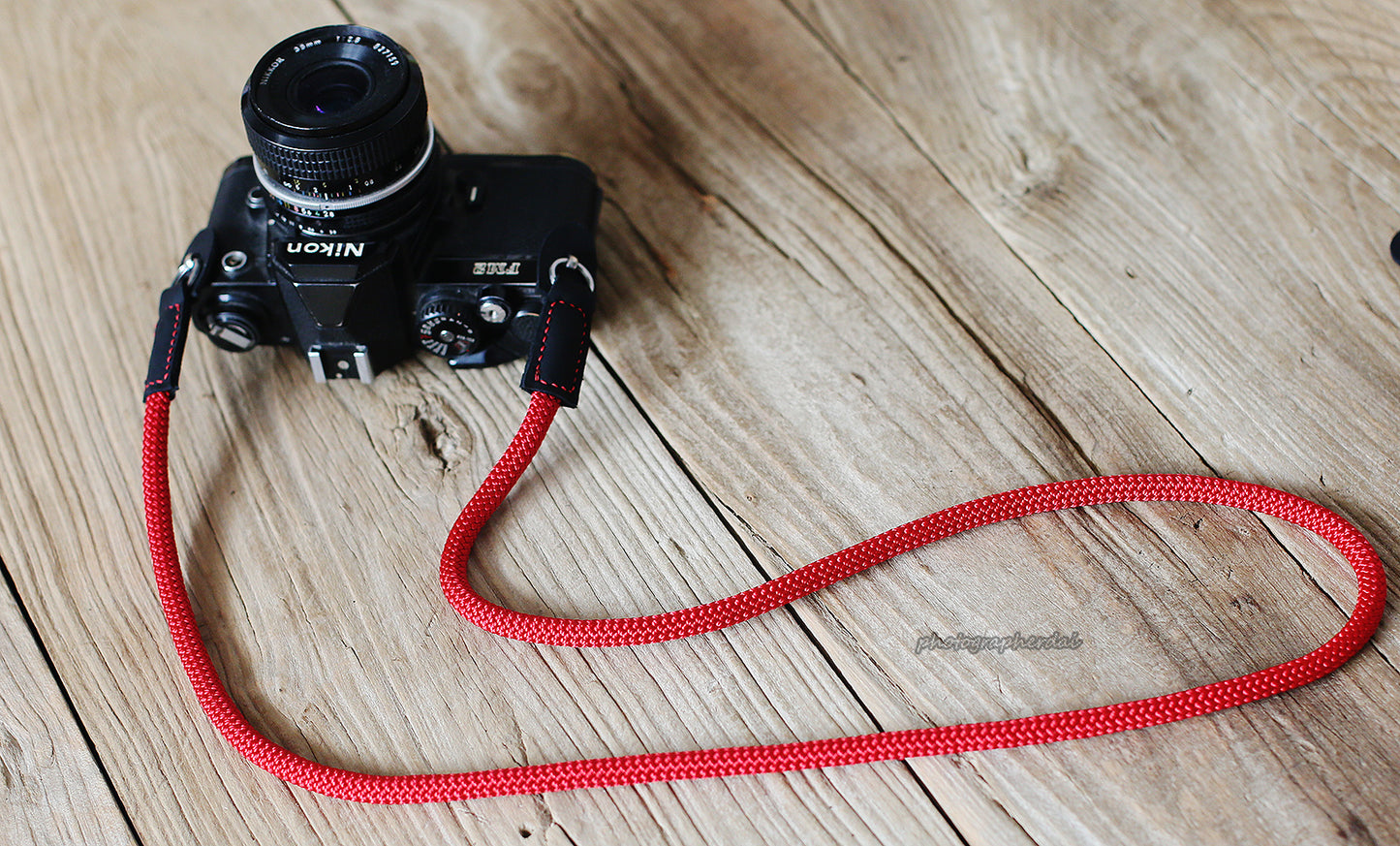 Red rope strap paired with Nikon film camera
