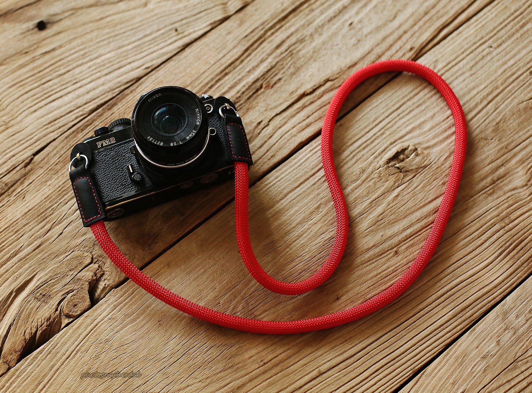 Detail shot of black full grain leather ends on red rope strap