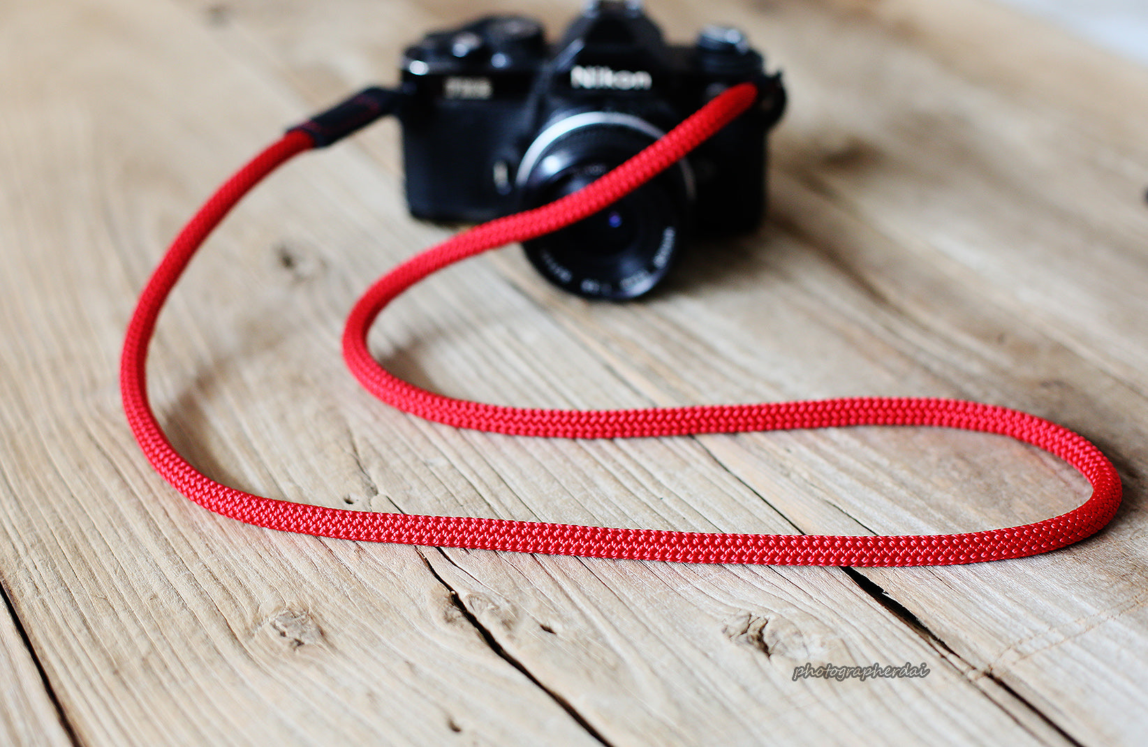 Angled view of red climbing rope camera strap
