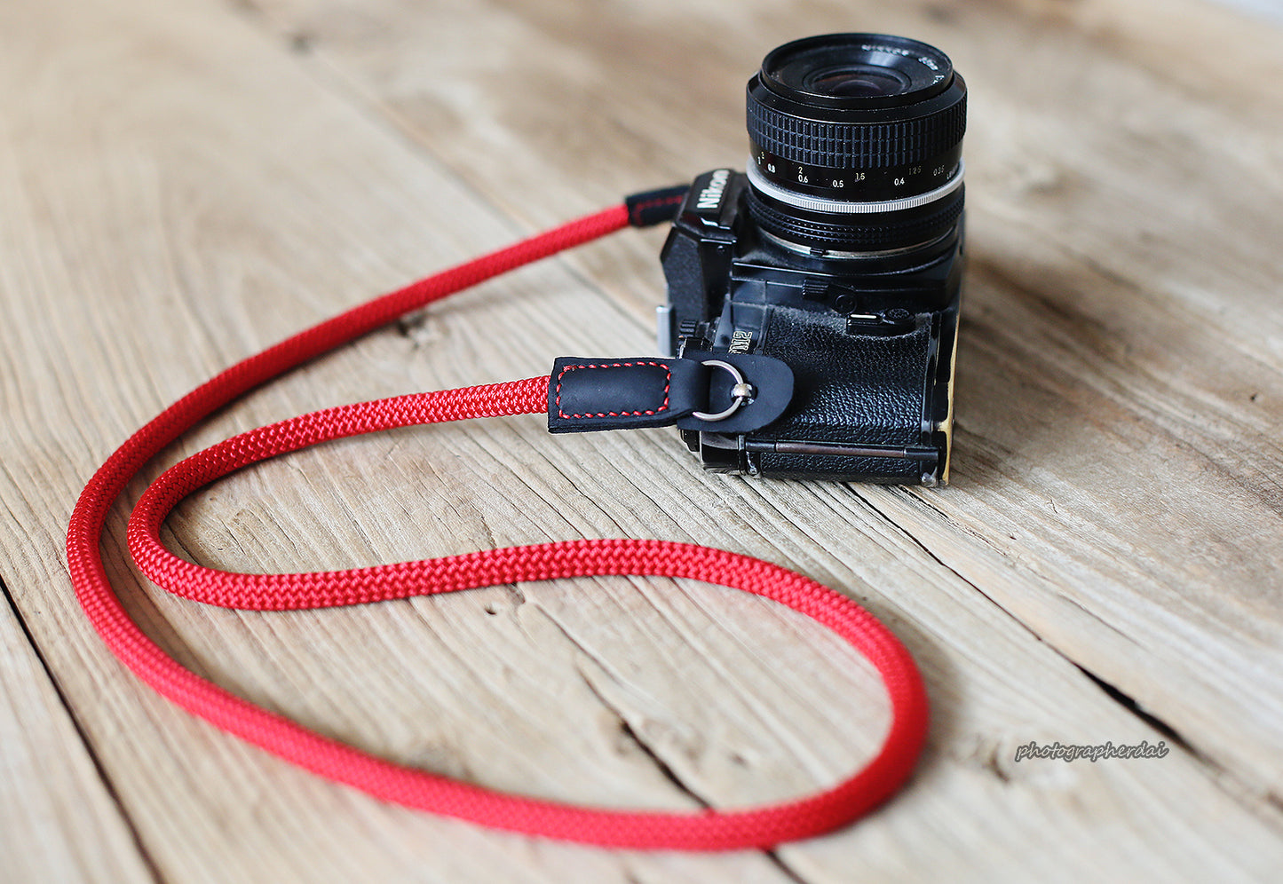 Flat-lay of red rope strap on wooden surface