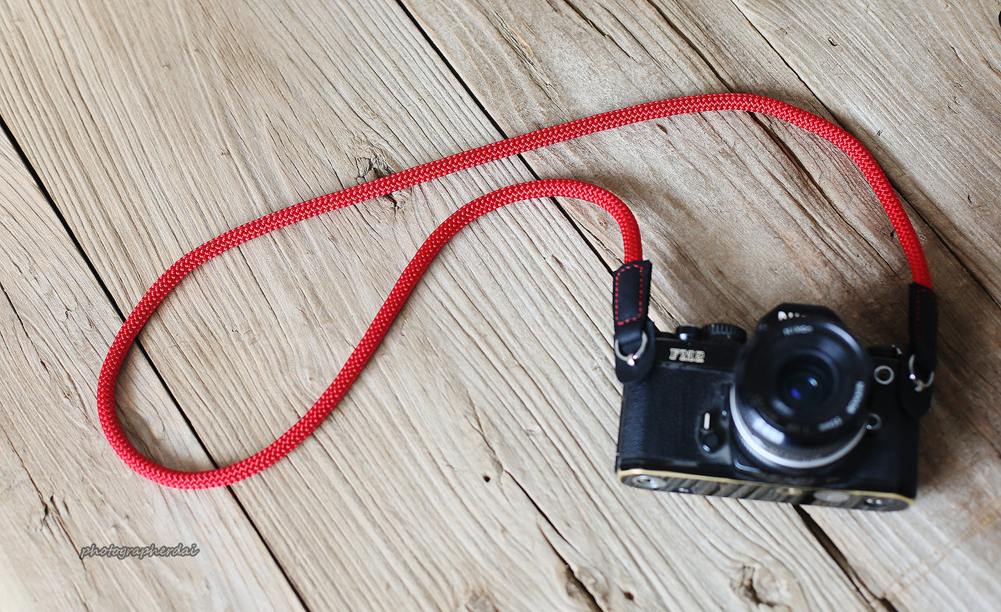 Red rope strap mounted on film camera
