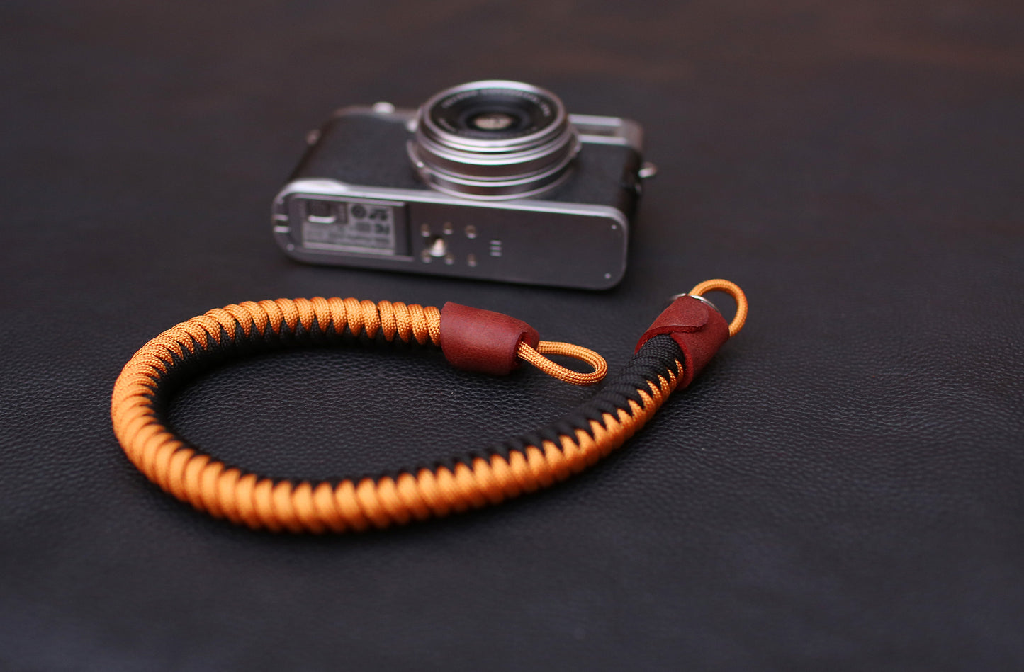 Flat lay of vintage camera with black-gold wrist strap