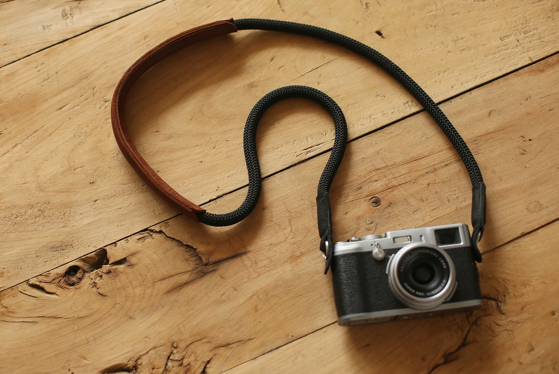 minimalist black rope strap with padded brown shoulder support