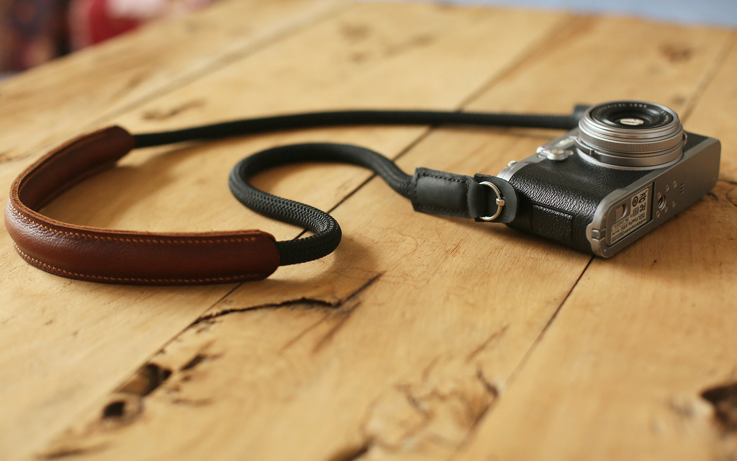 handcrafted camera strap with black rope and brown leather cushioning