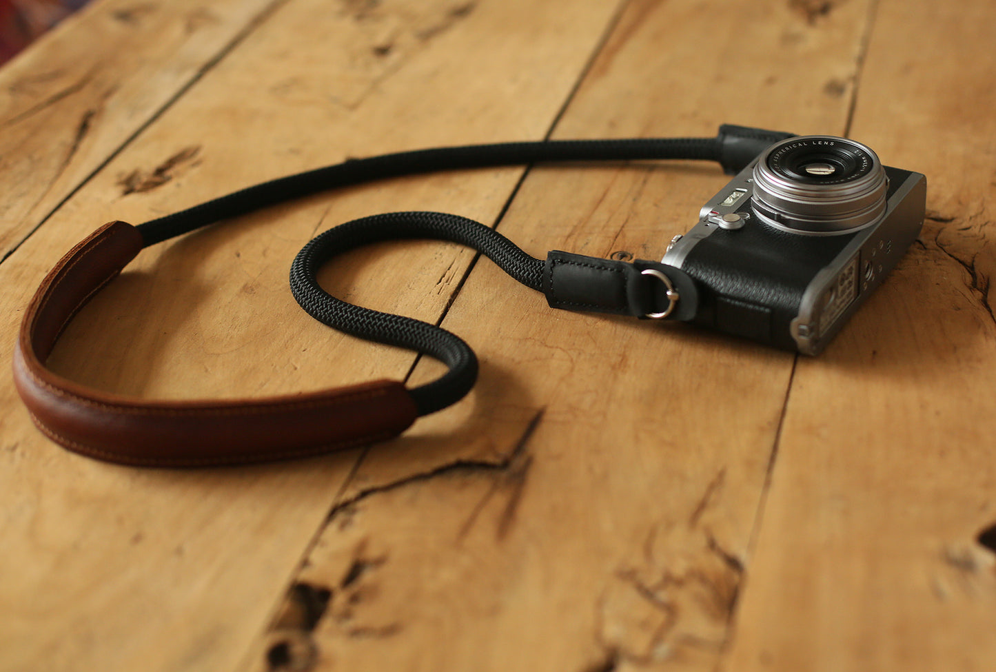 close up of brown leather shoulder cushion on rope camera strap